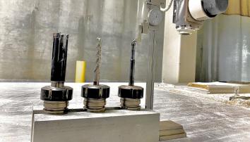 three drill bits on a workshop table